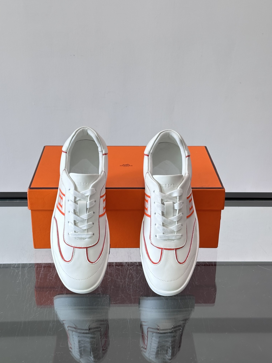 ​​Hermès 男士休闲运动鞋​​，皮革鞋面，鞋侧有橙色 H logo 织带装饰，白色橡胶鞋底。 In-the-Loo