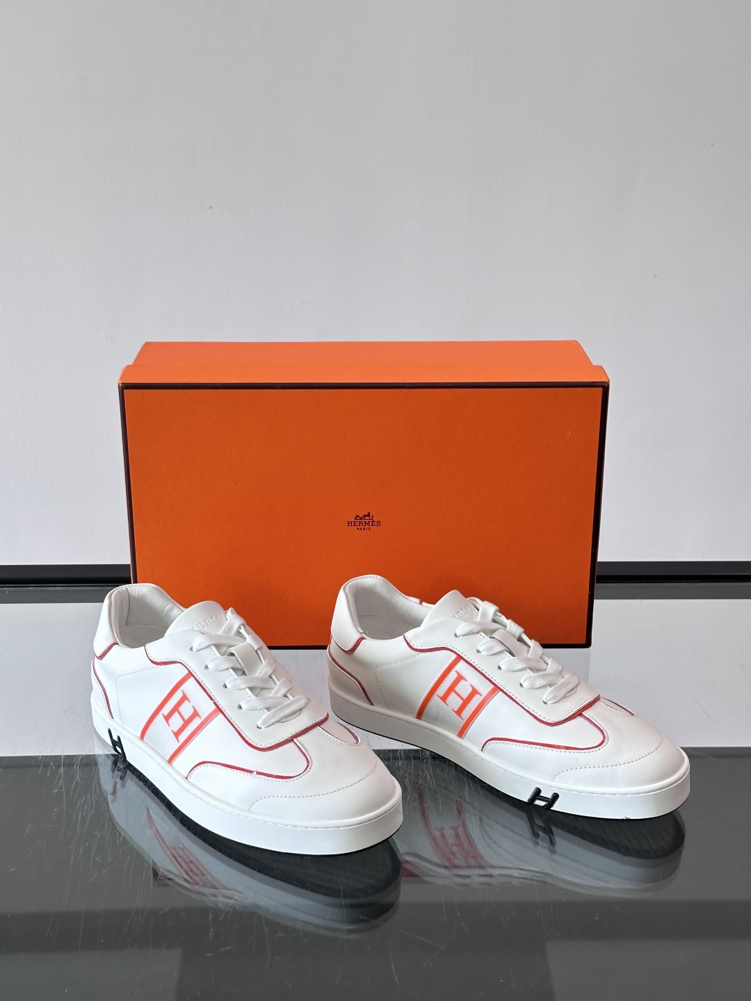 ​​Hermès 男士休闲运动鞋​​，皮革鞋面，鞋侧有橙色 H logo 织带装饰，白色橡胶鞋底。 In-the-Loo