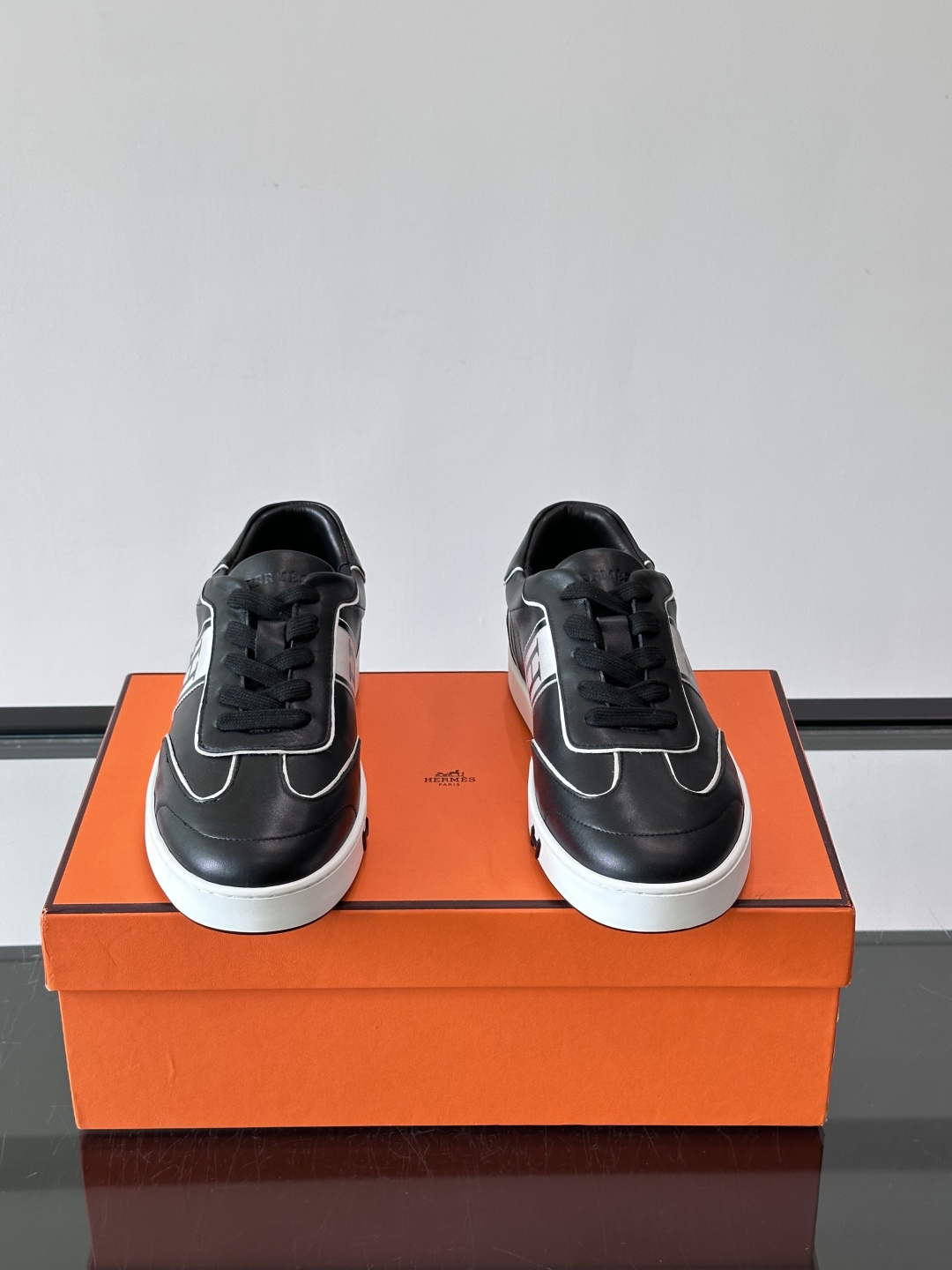 Hermès 男士休闲运动鞋,皮革鞋面,鞋侧有橙色 H logo 织带装饰,白色橡胶鞋底。 In-the-Loo Hermès 男士休闲运动鞋,皮革鞋面,鞋侧有橙色 H logo 织带装饰,白色橡胶鞋底。 In-the-Loo