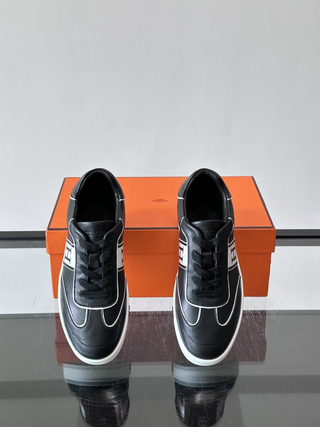 Hermès 男士休闲运动鞋,皮革鞋面,鞋侧有橙色 H logo 织带装饰,白色橡胶鞋底。 In-the-Loo Hermès 男士休闲运动鞋,皮革鞋面,鞋侧有橙色 H logo 织带装饰,白色橡胶鞋底。 In-the-Loo