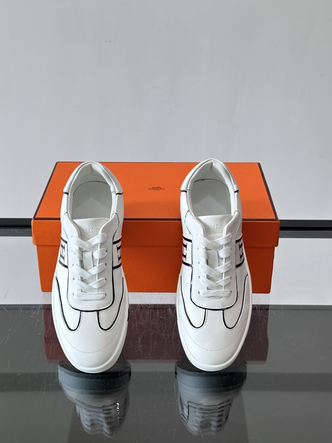 Hermès 男士休闲运动鞋,皮革鞋面,鞋侧有橙色 H logo 织带装饰,白色橡胶鞋底。 In-the-Loo Hermès 男士休闲运动鞋,皮革鞋面,鞋侧有橙色 H logo 织带装饰,白色橡胶鞋底。 In-the-Loo