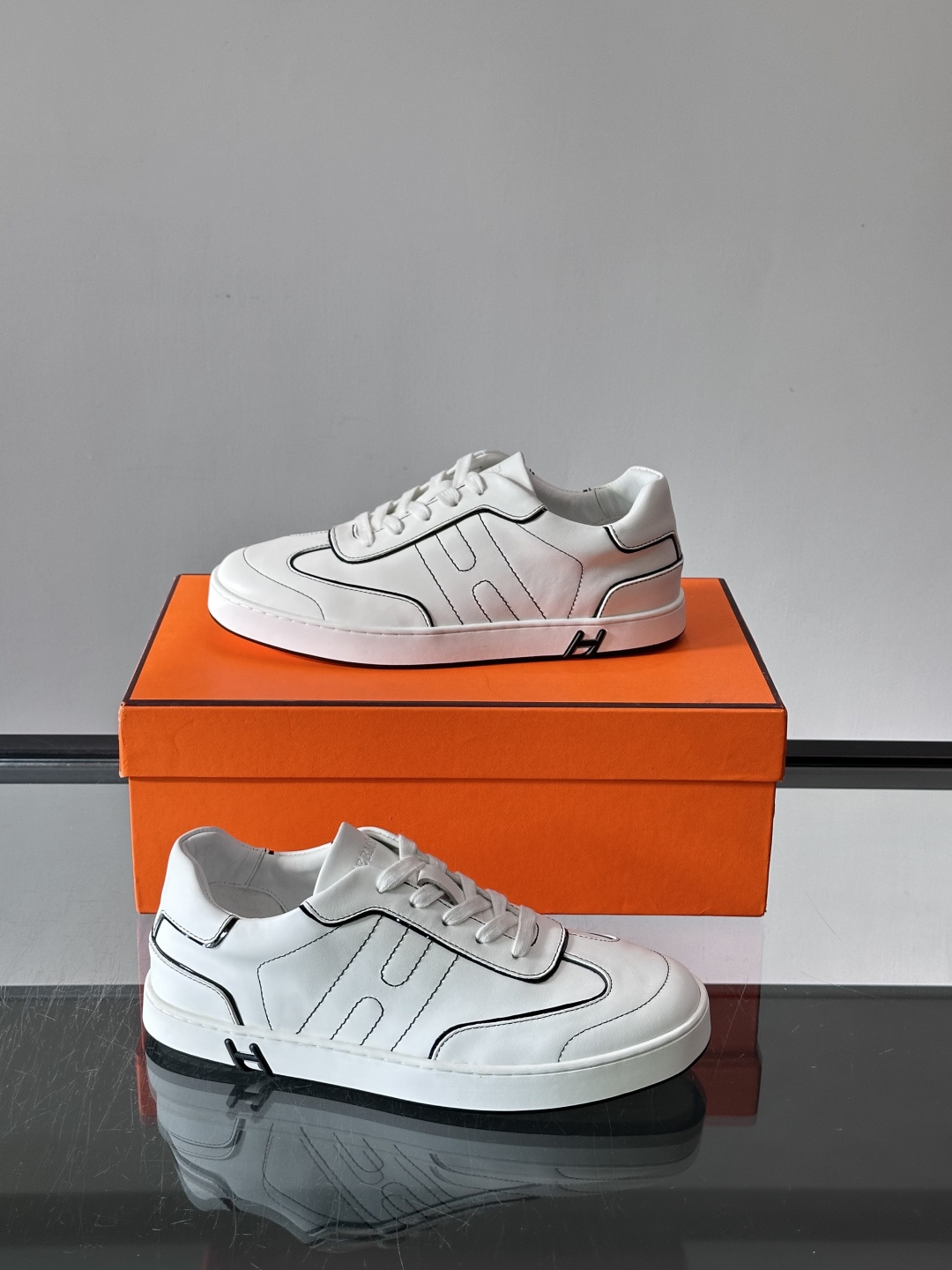 Hermès 男士休闲运动鞋,皮革鞋面,鞋侧有橙色 H logo 织带装饰,白色橡胶鞋底。 In-the-Loo Hermès 男士休闲运动鞋,皮革鞋面,鞋侧有橙色 H logo 织带装饰,白色橡胶鞋底。 In-the-Loo
