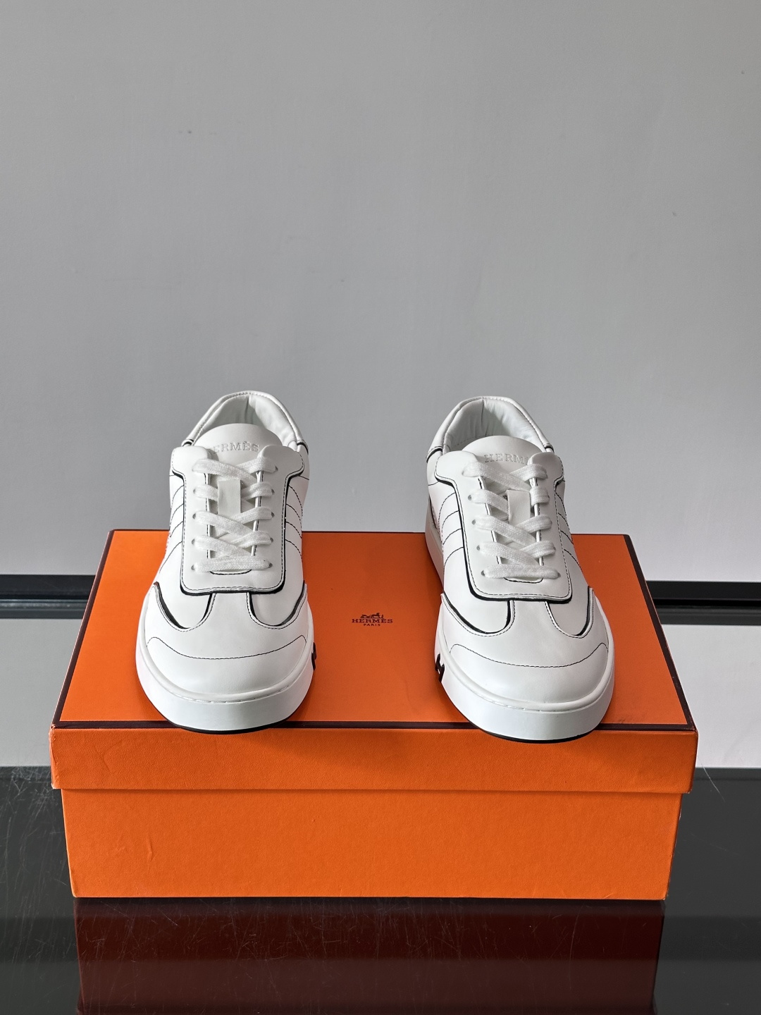 Hermès 男士休闲运动鞋,皮革鞋面,鞋侧有橙色 H logo 织带装饰,白色橡胶鞋底。 In-the-Loo Hermès 男士休闲运动鞋,皮革鞋面,鞋侧有橙色 H logo 织带装饰,白色橡胶鞋底。 In-the-Loo