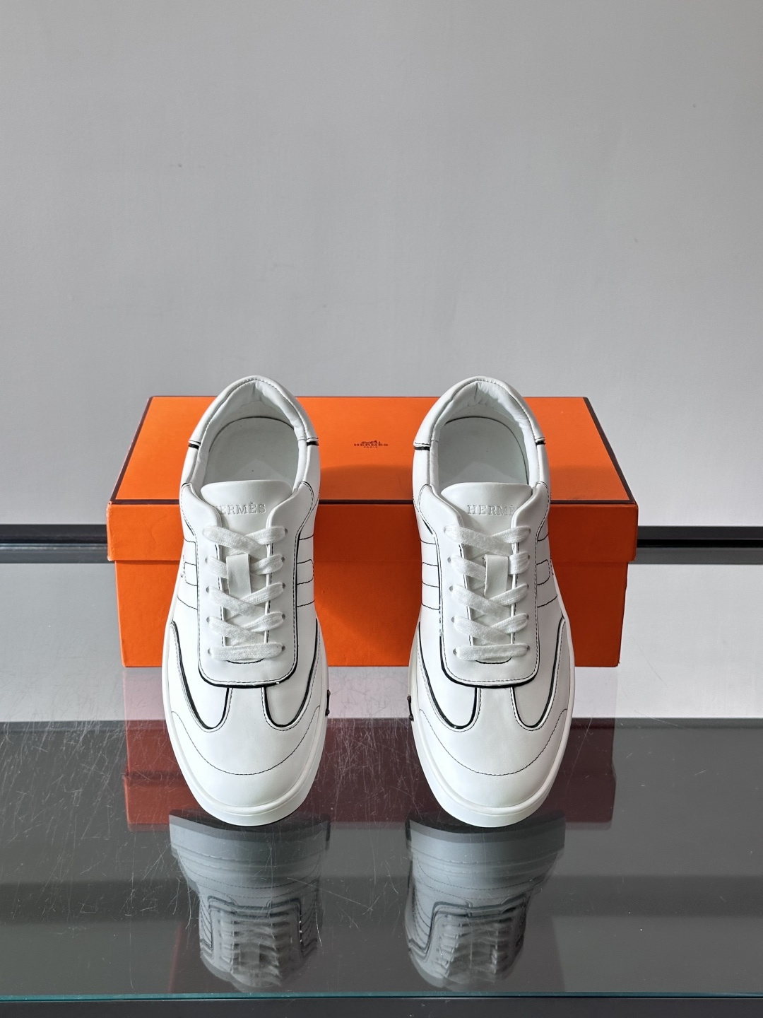 Hermès 男士休闲运动鞋,皮革鞋面,鞋侧有橙色 H logo 织带装饰,白色橡胶鞋底。 In-the-Loo Hermès 男士休闲运动鞋,皮革鞋面,鞋侧有橙色 H logo 织带装饰,白色橡胶鞋底。 In-the-Loo