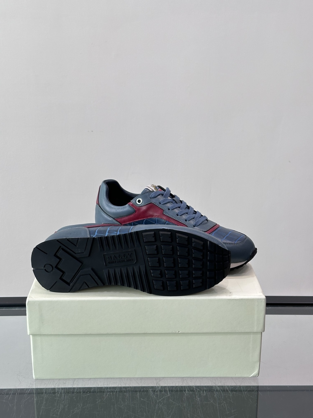 ​​Bally 男士运动鞋​​，皮革 ➕ 麂皮拼接鞋面，鞋侧有 BALLY 压印 logo，撞色中底，鞋舌上有品牌徽章。