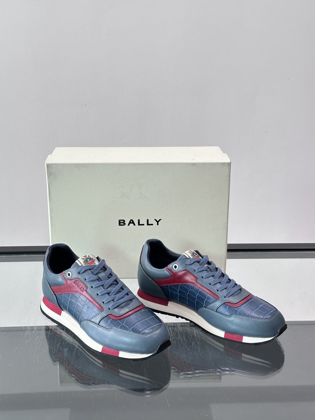 ​​Bally 男士运动鞋​​，皮革 ➕ 麂皮拼接鞋面，鞋侧有 BALLY 压印 logo，撞色中底，鞋舌上有品牌徽章。