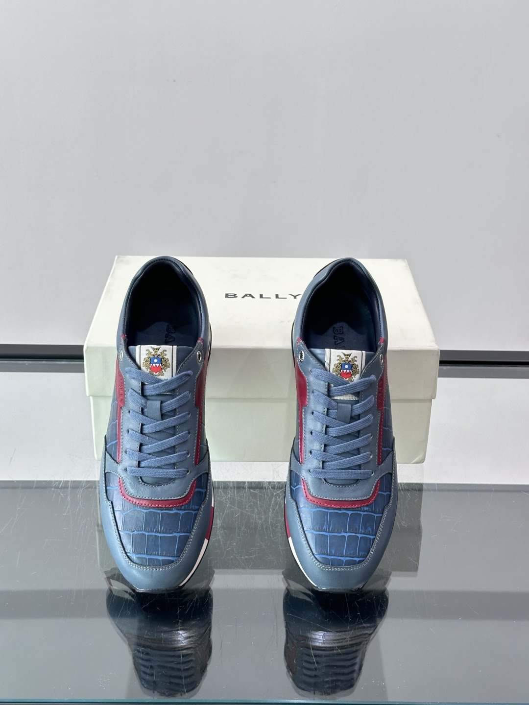 ​​Bally 男士运动鞋​​，皮革 ➕ 麂皮拼接鞋面，鞋侧有 BALLY 压印 logo，撞色中底，鞋舌上有品牌徽章。
