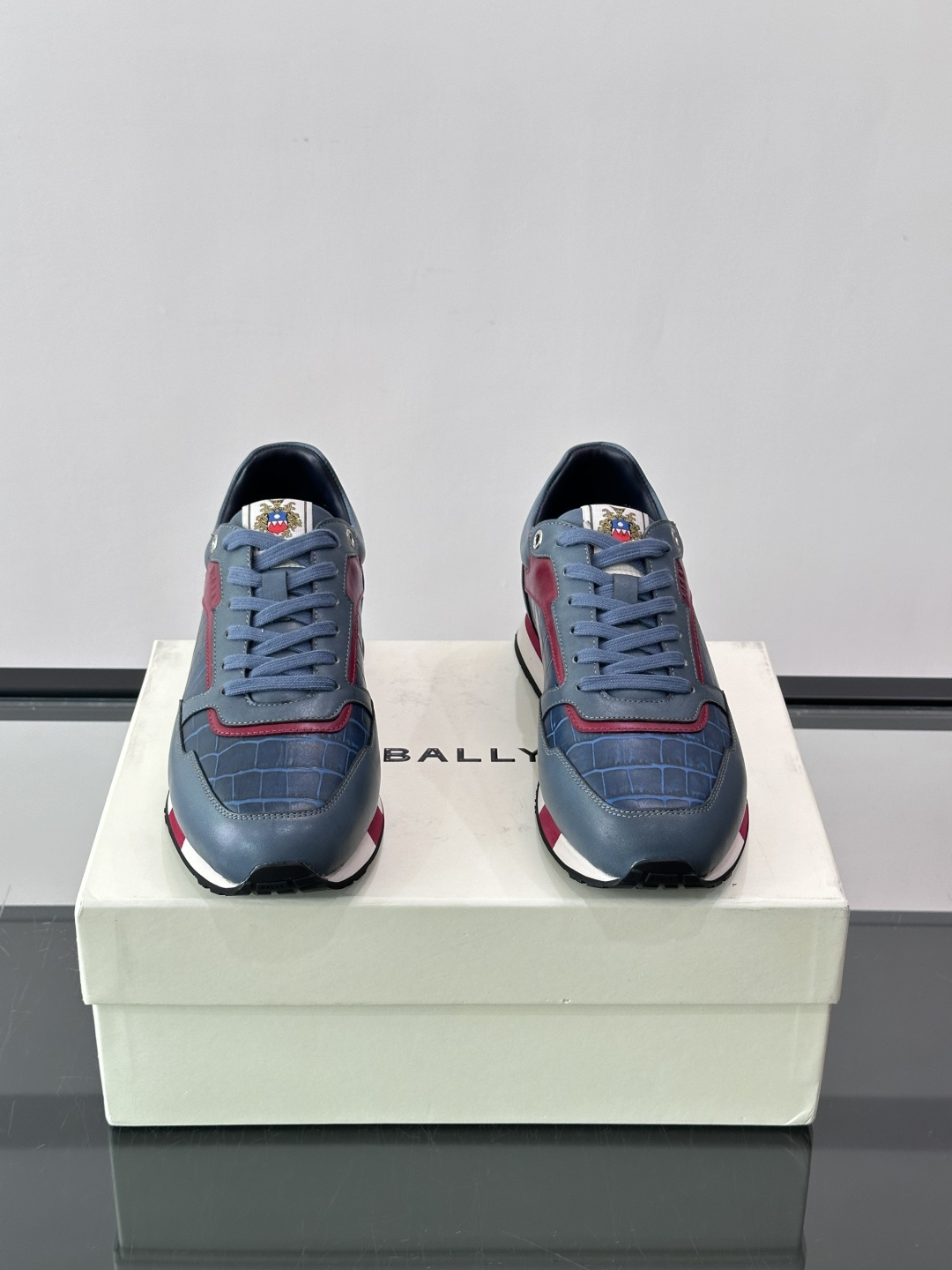 ​​Bally 男士运动鞋​​，皮革 ➕ 麂皮拼接鞋面，鞋侧有 BALLY 压印 logo，撞色中底，鞋舌上有品牌徽章。