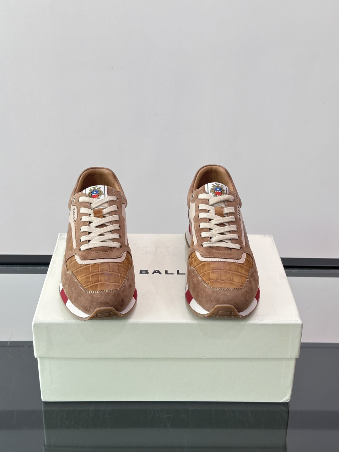 ​​Bally 男士运动鞋​​，皮革 ➕ 麂皮拼接鞋面，鞋侧有 BALLY 压印 logo，撞色中底，鞋舌上有品牌徽章。