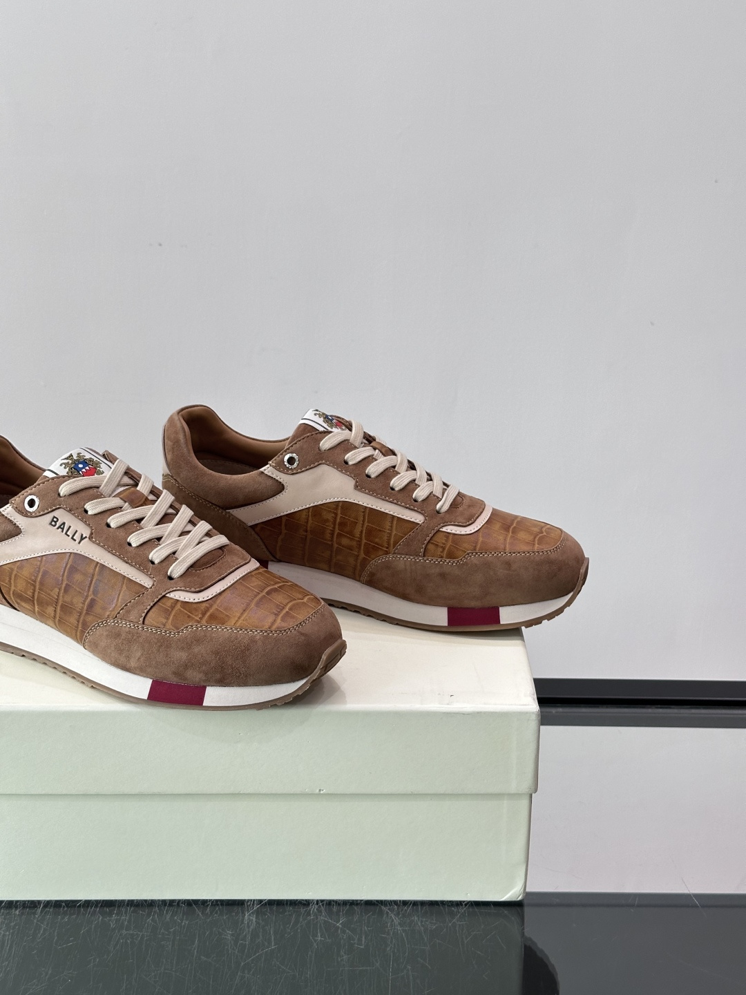 ​​Bally 男士运动鞋​​，皮革 ➕ 麂皮拼接鞋面，鞋侧有 BALLY 压印 logo，撞色中底，鞋舌上有品牌徽章。