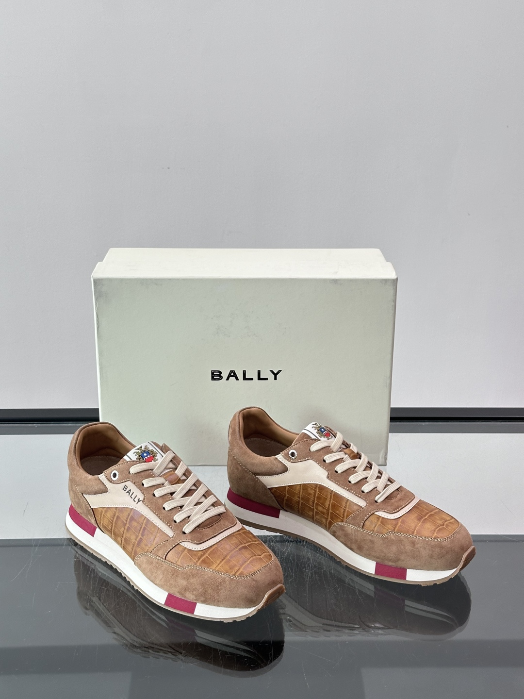 ​​Bally 男士运动鞋​​，皮革 ➕ 麂皮拼接鞋面，鞋侧有 BALLY 压印 logo，撞色中底，鞋舌上有品牌徽章。