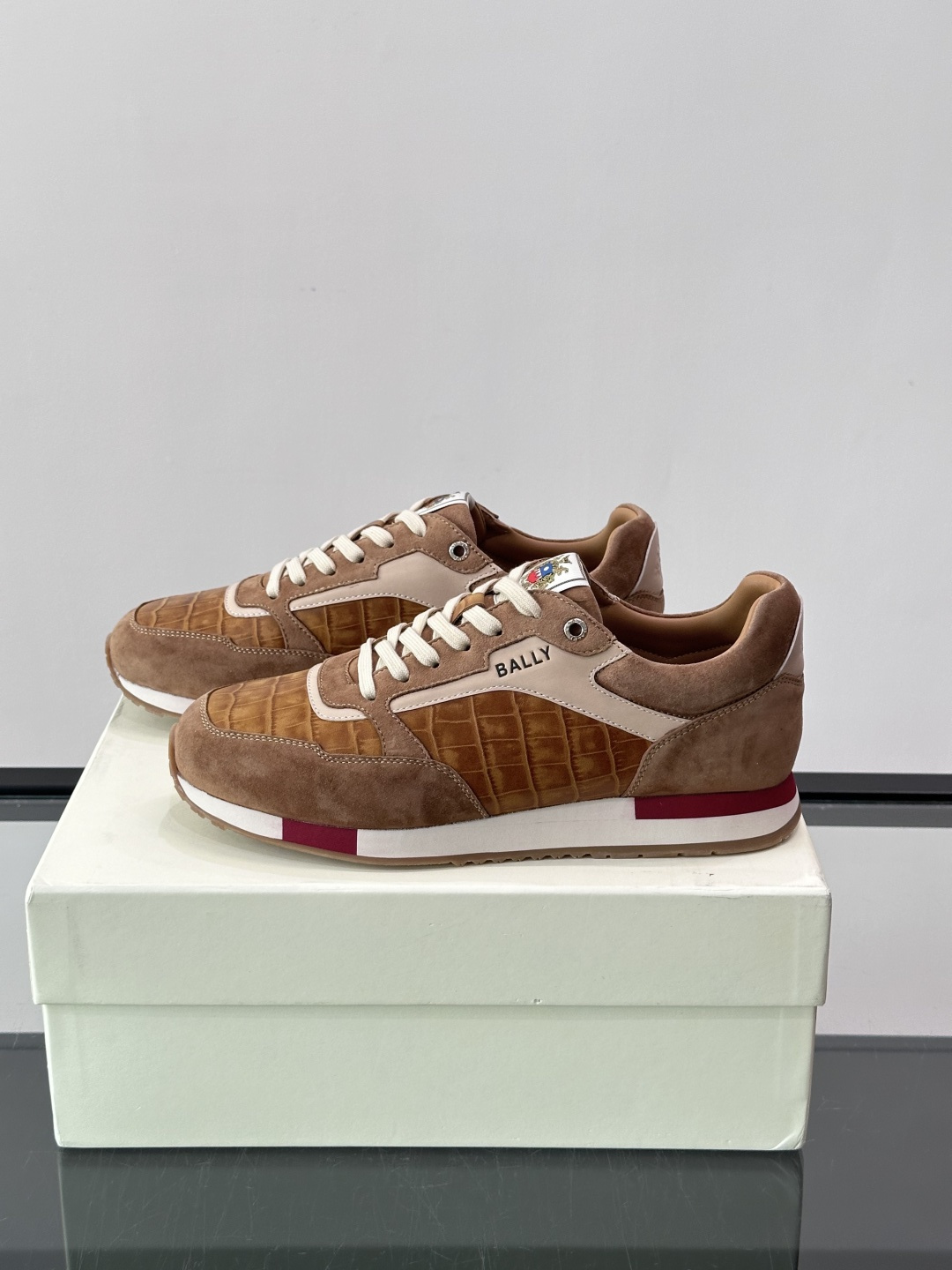 ​​Bally 男士运动鞋​​，皮革 ➕ 麂皮拼接鞋面，鞋侧有 BALLY 压印 logo，撞色中底，鞋舌上有品牌徽章。