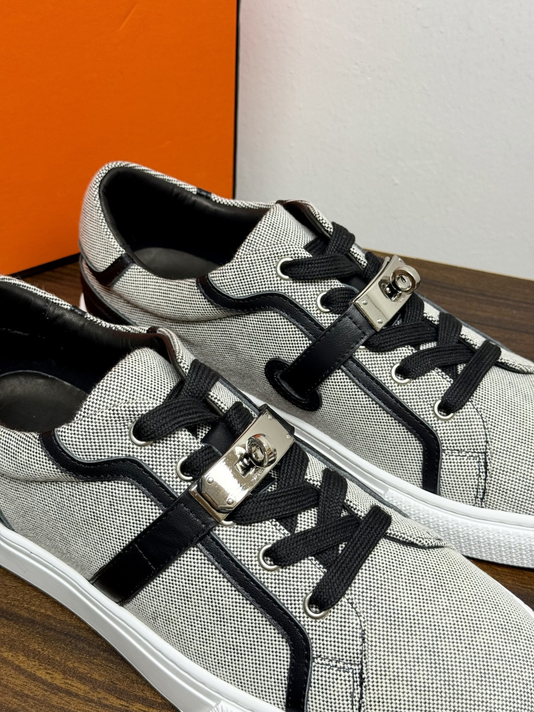 Hermès Kelly扣帆布板鞋​，鞋面是灰色H帆布 + 小牛皮拼接，最大辨识点是鞋带上那颗 ​​镀钯Kelly金属锁