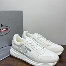 Prada Brush 运动鞋,鞋面是麂皮 + 尼龙织物拼接,侧面有 Prada 标志性的 三角珐琅金属标 ,厚底橡 Prada Brush 运动鞋,鞋面是麂皮 + 尼龙织物拼接,侧面有 Prada 标志性的 三角珐琅金属标 ,厚底橡