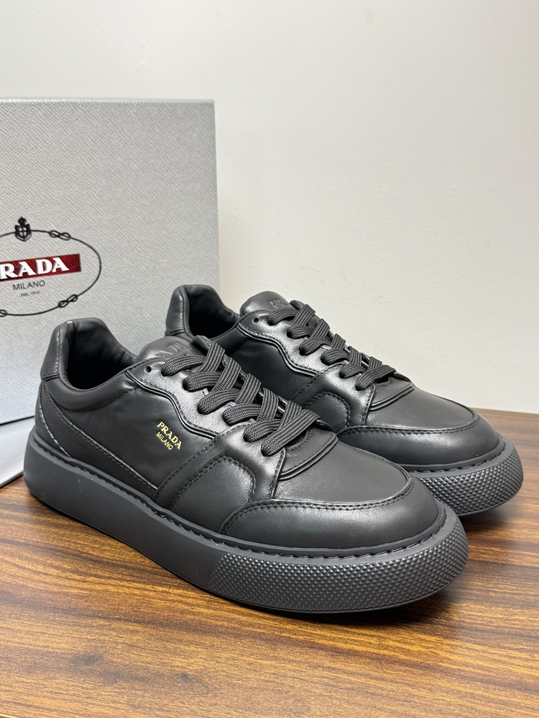 Prada Court 板鞋,整体造型很极简,鞋面是柔软的小牛皮,鞋侧金色 PRADA 压印 logo( Prada Court 板鞋,整体造型很极简,鞋面是柔软的小牛皮,鞋侧金色 PRADA 压印 logo(