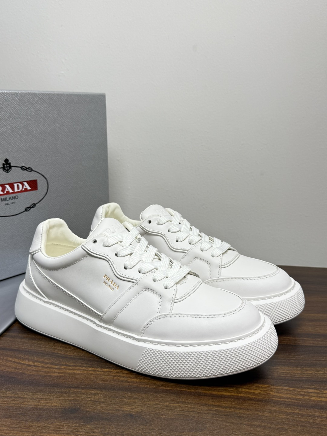 Prada Court 板鞋,整体造型很极简,鞋面是柔软的小牛皮,鞋侧金色 PRADA 压印 logo( Prada Court 板鞋,整体造型很极简,鞋面是柔软的小牛皮,鞋侧金色 PRADA 压印 logo(