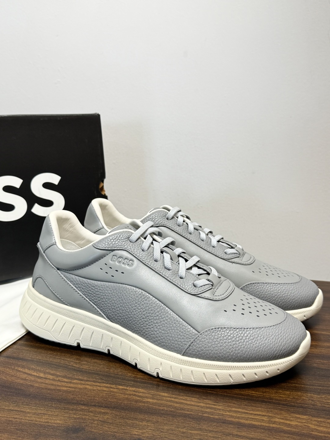 Hugo Boss 男士皮质休闲板鞋,鞋面是 荔枝纹牛皮 / 纳帕皮 ,鞋身有透气打孔设计,侧面压印或金属 BOSS Hugo Boss 男士皮质休闲板鞋,鞋面是 荔枝纹牛皮 / 纳帕皮 ,鞋身有透气打孔设计,侧面压印或金属 BOSS