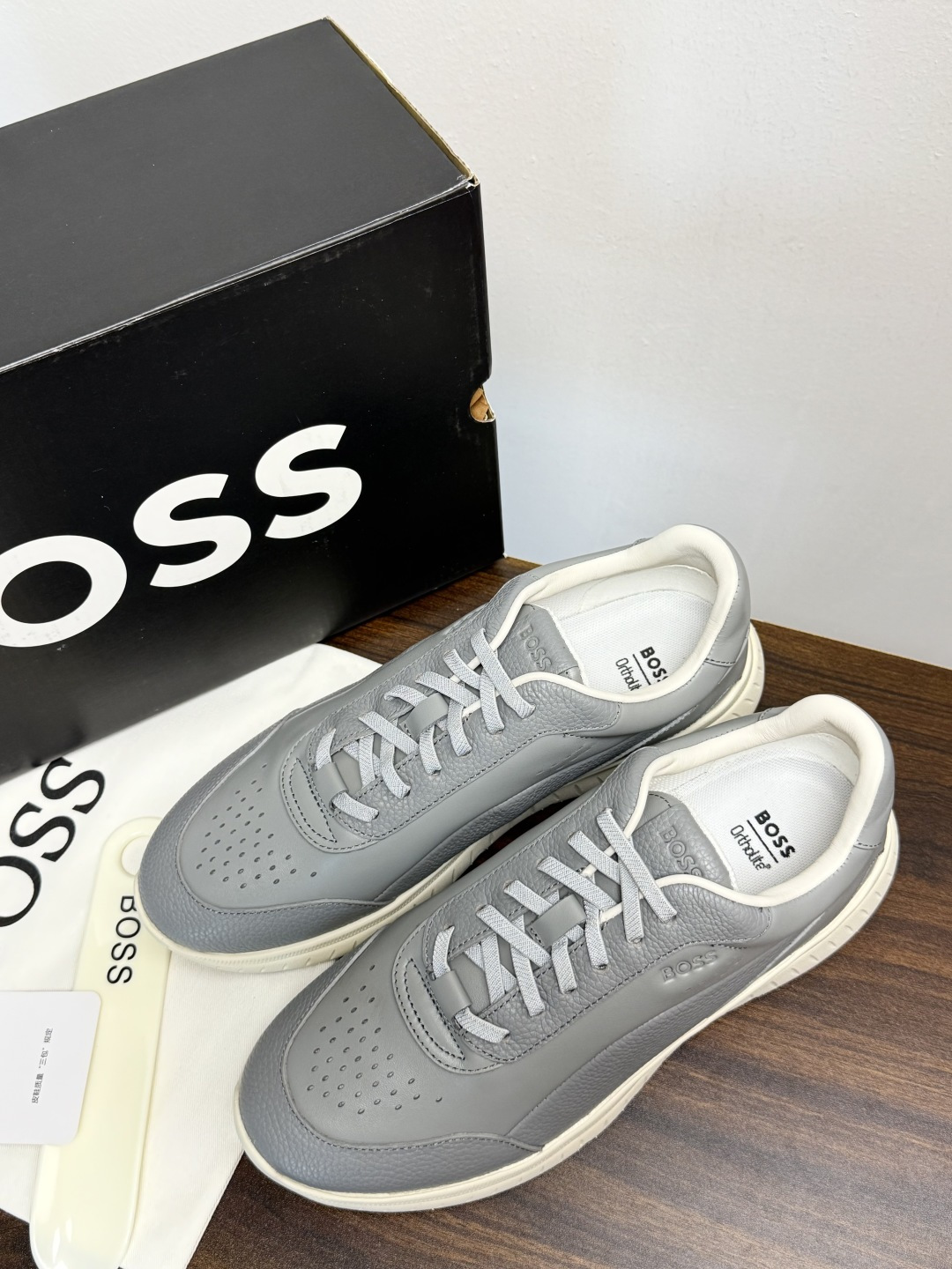 Hugo Boss 男士皮质休闲板鞋,鞋面是 荔枝纹牛皮 / 纳帕皮 ,鞋身有透气打孔设计,侧面压印或金属 BOSS Hugo Boss 男士皮质休闲板鞋,鞋面是 荔枝纹牛皮 / 纳帕皮 ,鞋身有透气打孔设计,侧面压印或金属 BOSS