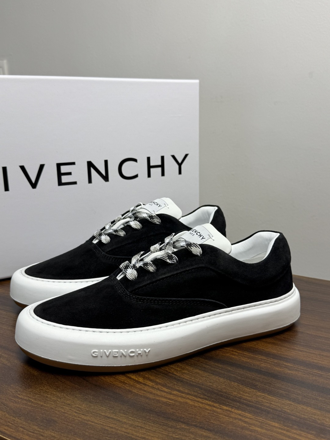 Givenchy 麂皮板鞋​​，鞋面是 ​​全麂皮​​材质，质感柔软有绒毛感，白色橡胶厚底侧面压印 GIVENCHY 字