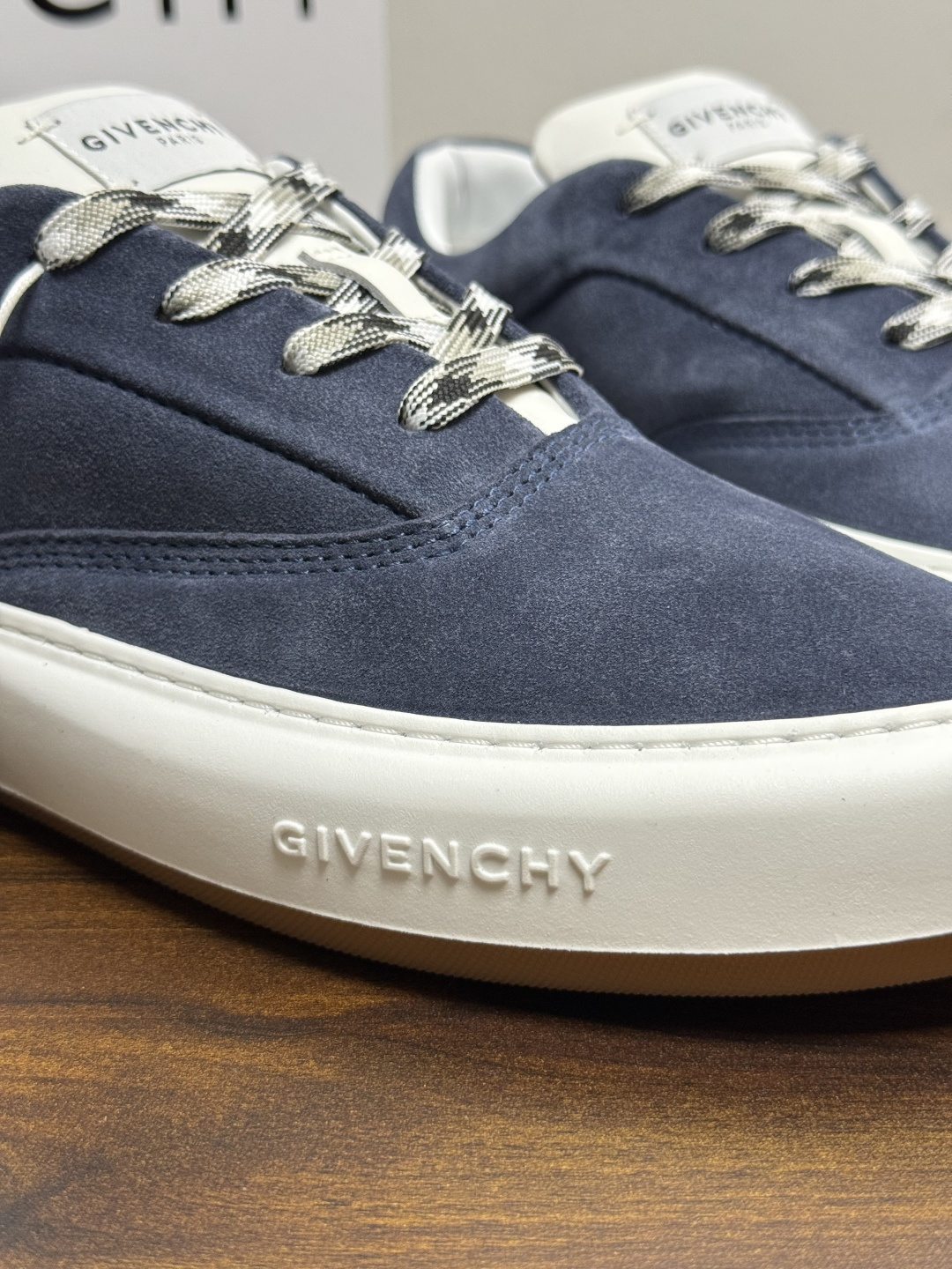 Givenchy 麂皮板鞋​​，鞋面是 ​​全麂皮​​材质，质感柔软有绒毛感，白色橡胶厚底侧面压印 GIVENCHY 字