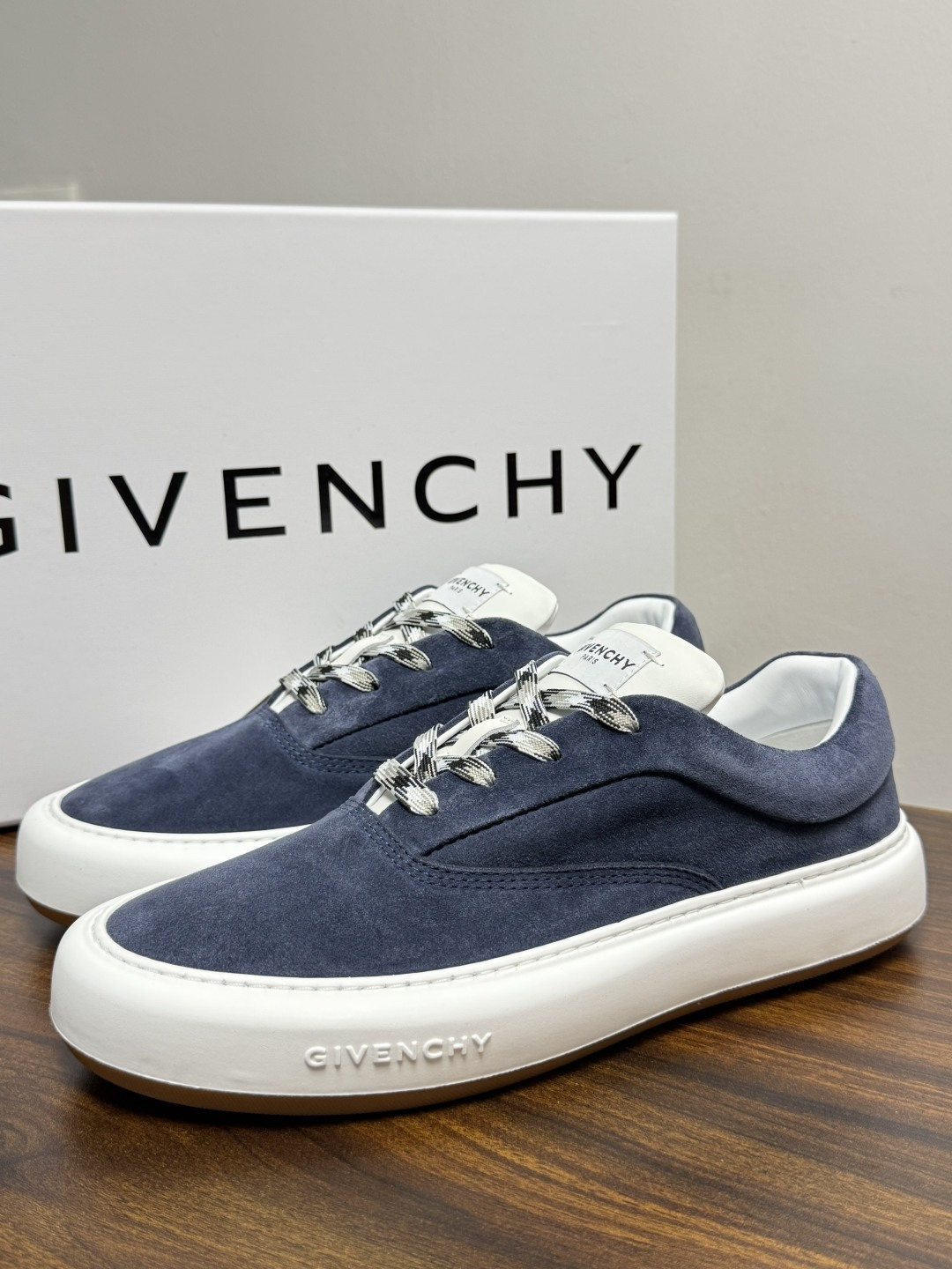 Givenchy 麂皮板鞋​​，鞋面是 ​​全麂皮​​材质，质感柔软有绒毛感，白色橡胶厚底侧面压印 GIVENCHY 字
