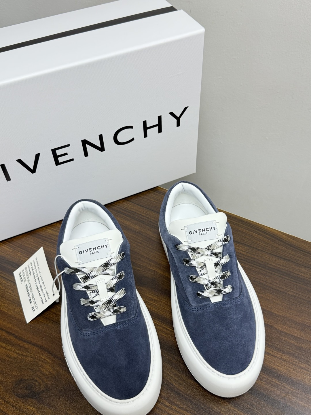 Givenchy 麂皮板鞋​​，鞋面是 ​​全麂皮​​材质，质感柔软有绒毛感，白色橡胶厚底侧面压印 GIVENCHY 字