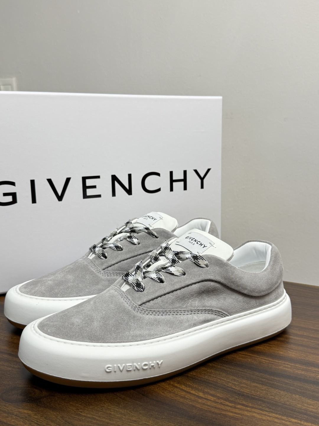 Givenchy 麂皮板鞋​​，鞋面是 ​​全麂皮​​材质，质感柔软有绒毛感，白色橡胶厚底侧面压印 GIVENCHY 字