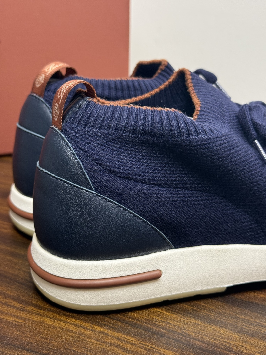 Loro Piana 针织袜套鞋​​，鞋面是针织/网眼袜套设计，整体造型是"静奢运动风"——远看像普通运动鞋，近看质感拉