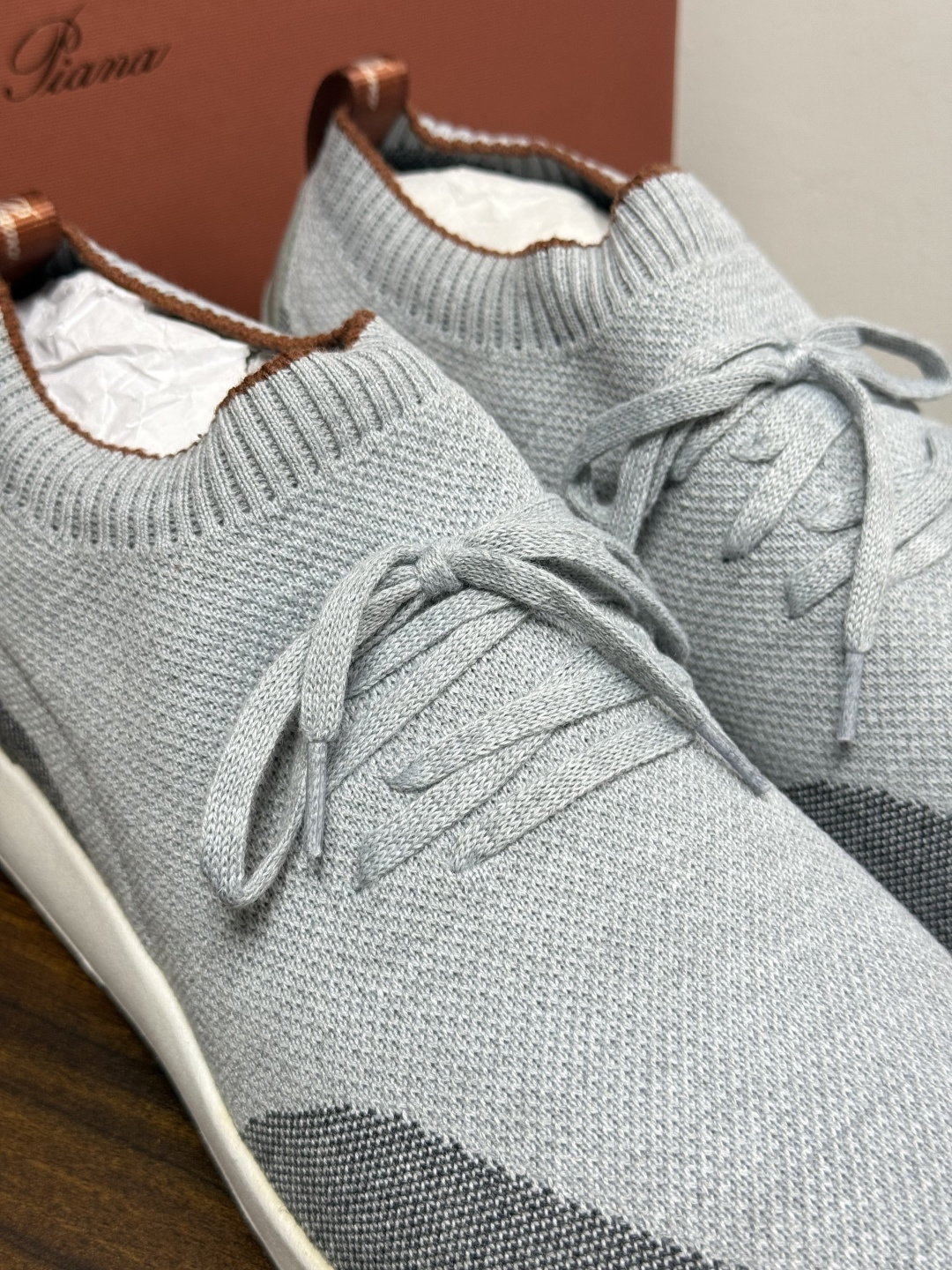Loro Piana 针织袜套鞋​​，鞋面是针织/网眼袜套设计，整体造型是"静奢运动风"——远看像普通运动鞋，近看质感拉