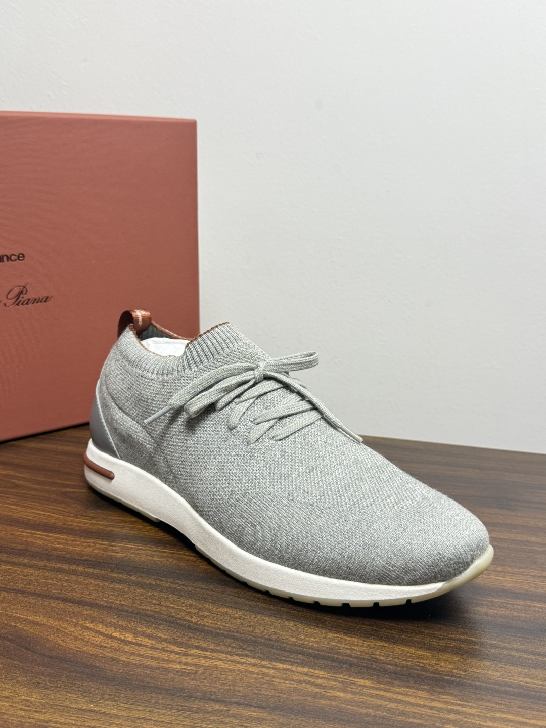 Loro Piana 针织袜套鞋​​，鞋面是针织/网眼袜套设计，整体造型是"静奢运动风"——远看像普通运动鞋，近看质感拉