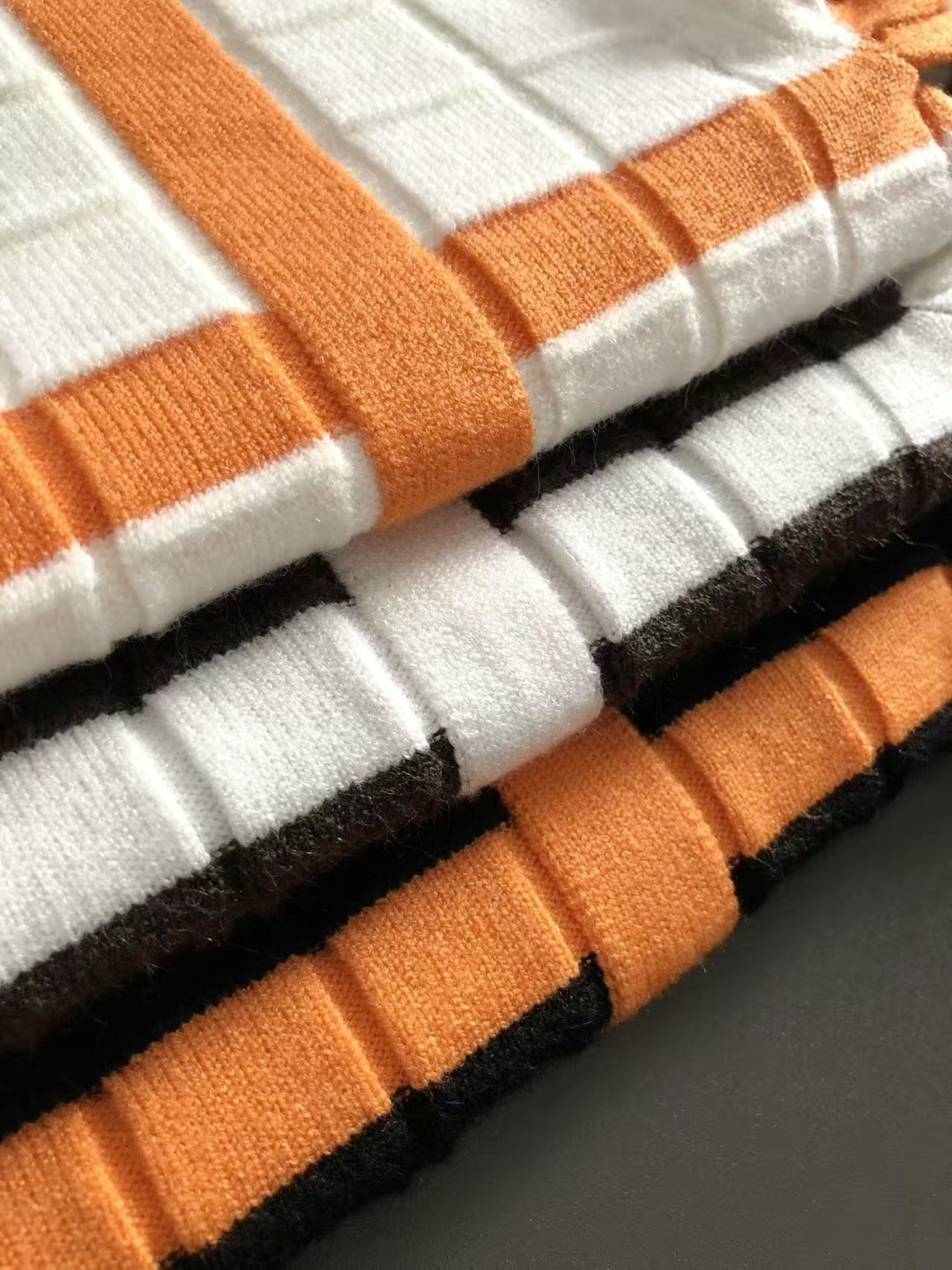 HMS*合身版型M-xxxl2025秋冬潮牌3色撞色羊毛衫，以领口不规则拼接点缀为主调，巧妙棋盘格的针法