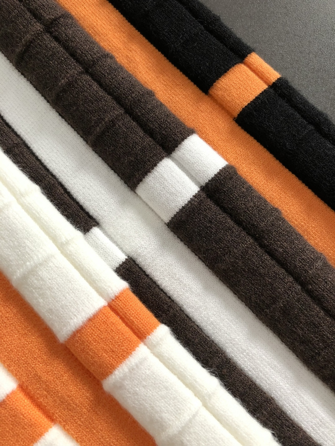 HMS*合身版型M-xxxl2025秋冬潮牌3色撞色羊毛衫，以领口不规则拼接点缀为主调，巧妙棋盘格的针法