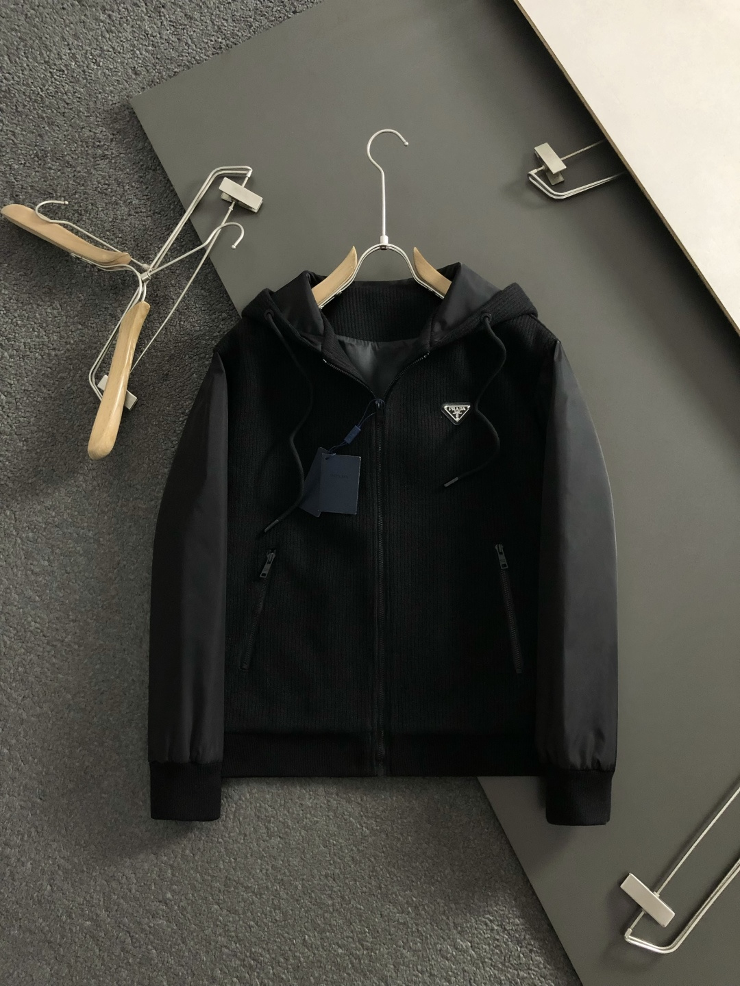 PRAD*合身版型M-XXXl2025秋冬潮牌拼接连帽外套，以经典三角元素融点缀为主调，巧妙专柜五金元素