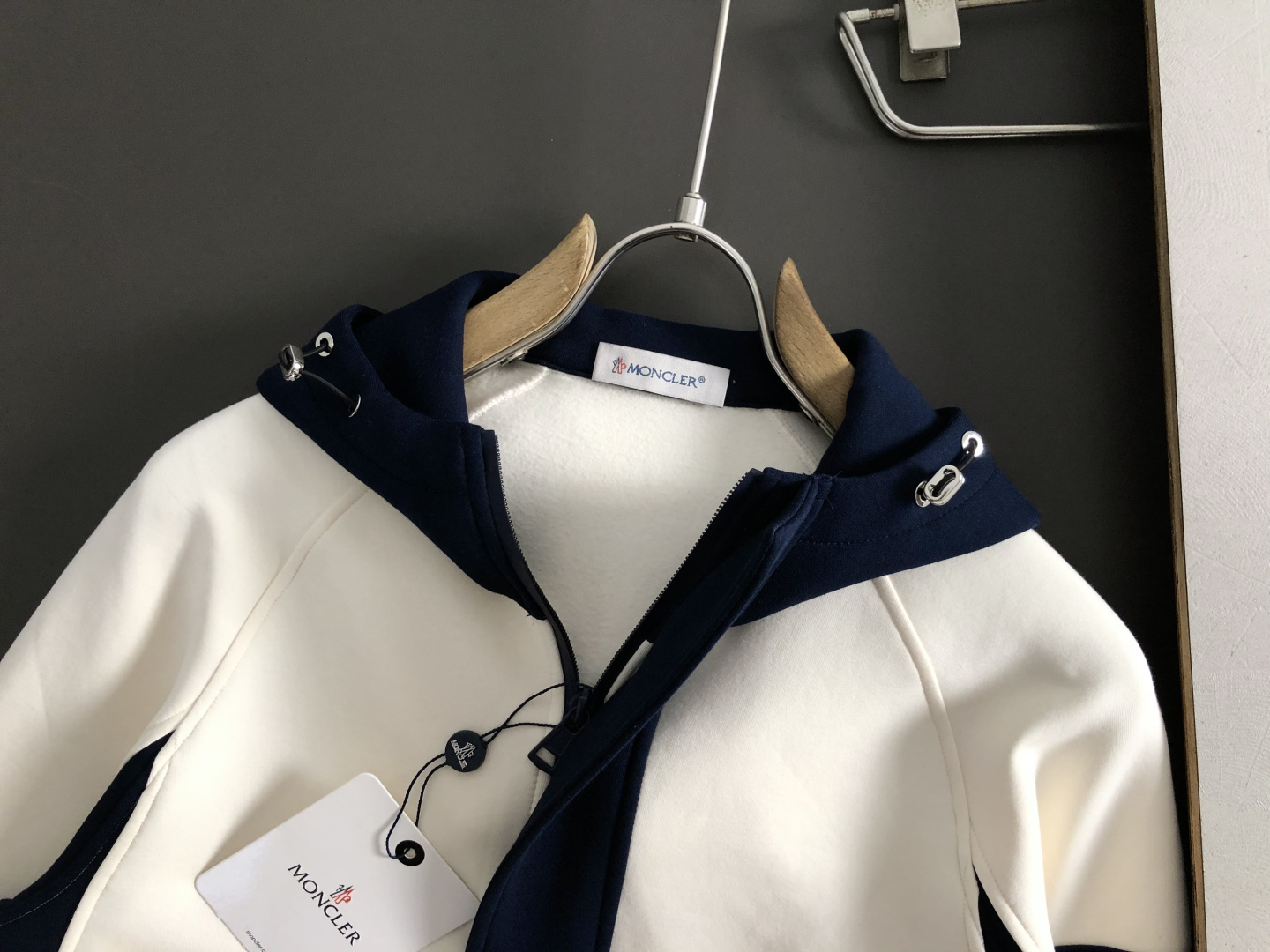 Mon*合身版型M-XXXl2025秋冬潮牌云柔系列连帽卫衣，以红黑撞色融合皮牌点缀为主调，巧妙融入多拼