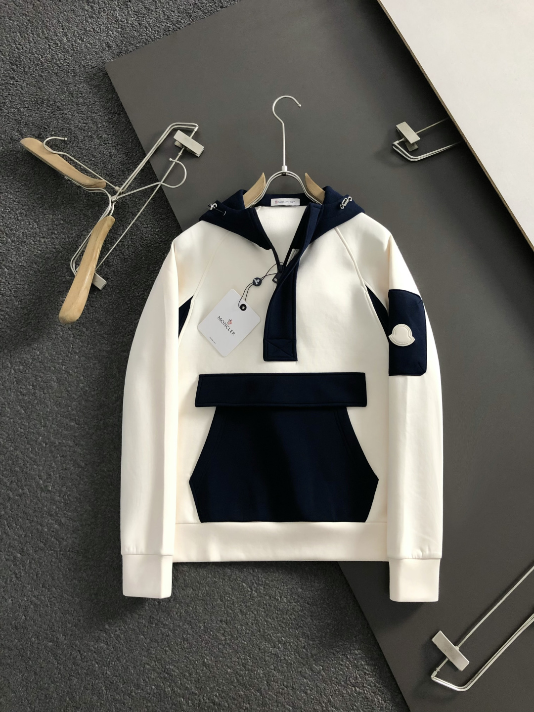 Mon*合身版型M-XXXl2025秋冬潮牌云柔系列连帽卫衣，以红黑撞色融合皮牌点缀为主调，巧妙融入多拼