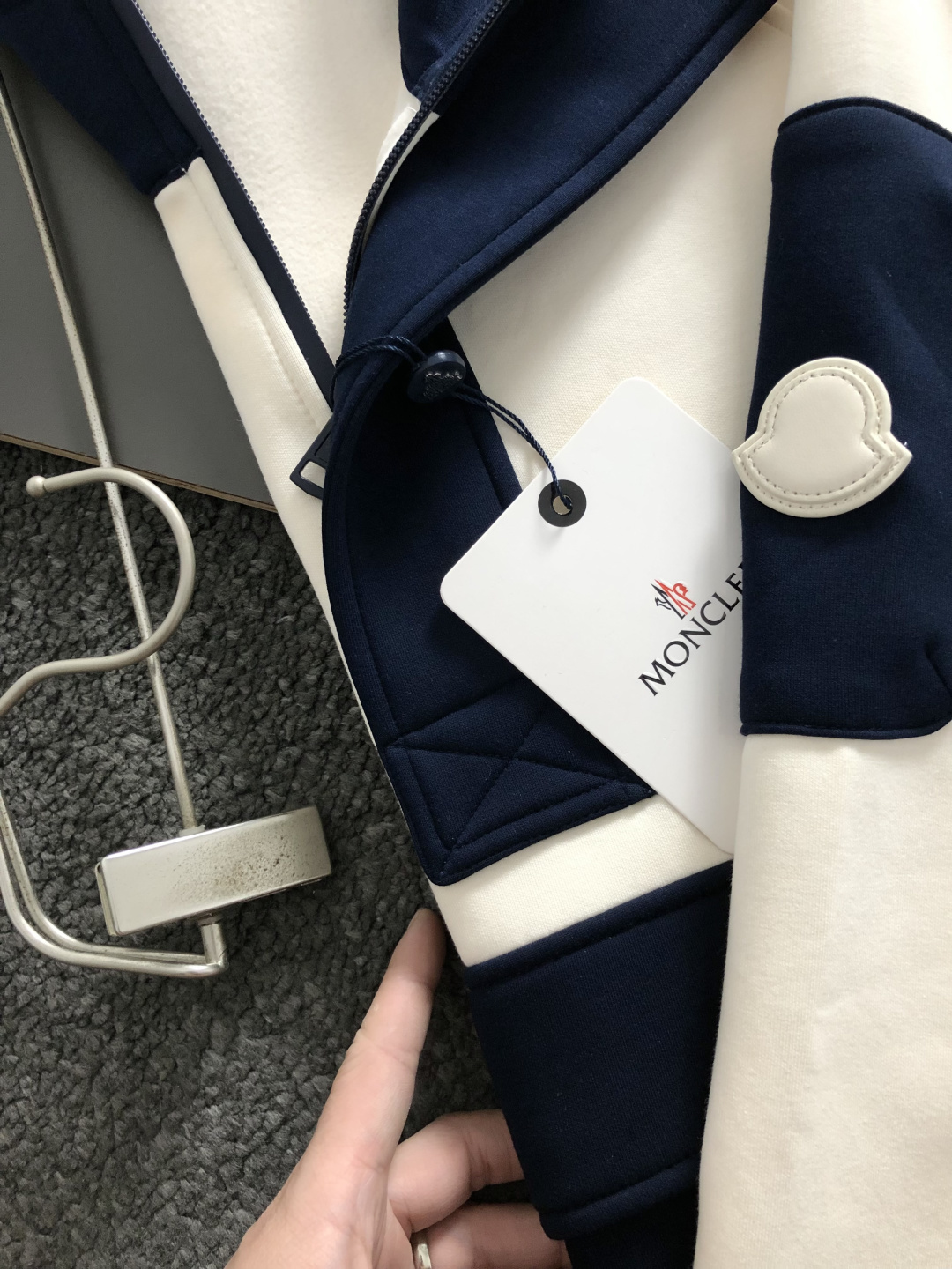 Mon*合身版型M-XXXl2025秋冬潮牌云柔系列连帽卫衣，以红黑撞色融合皮牌点缀为主调，巧妙融入多拼