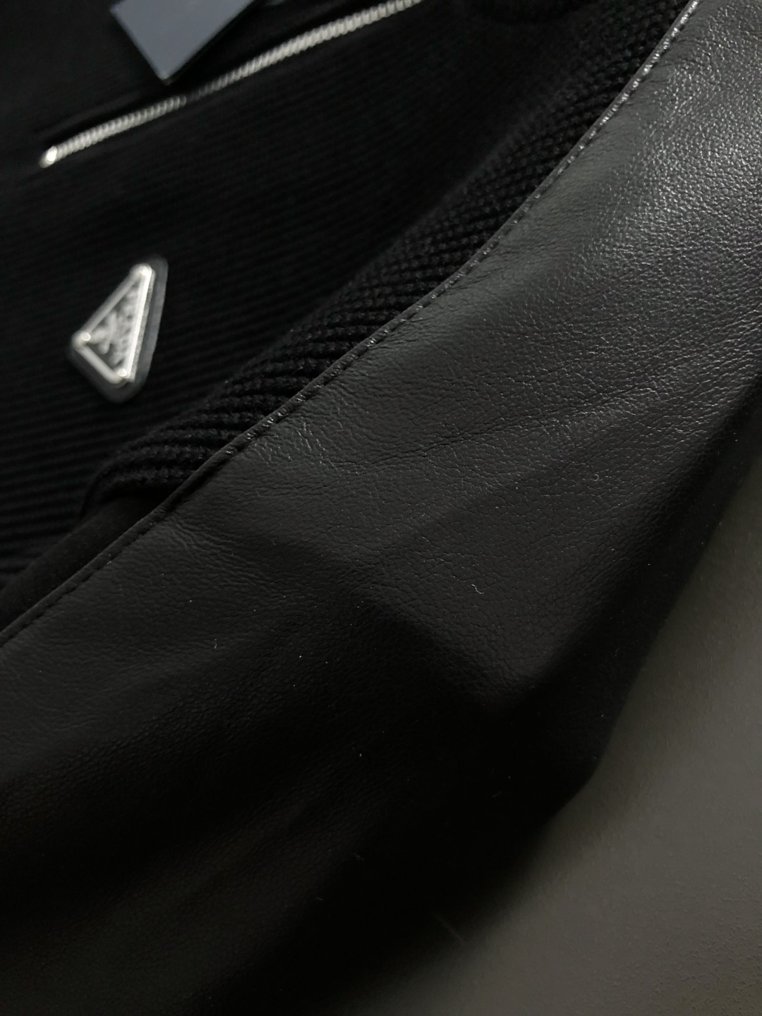 PRAD*合身版型M-XXXl2025秋冬潮牌云柔真皮拼接卫衣，以经典三角元素融点缀为主调，巧妙融入金属