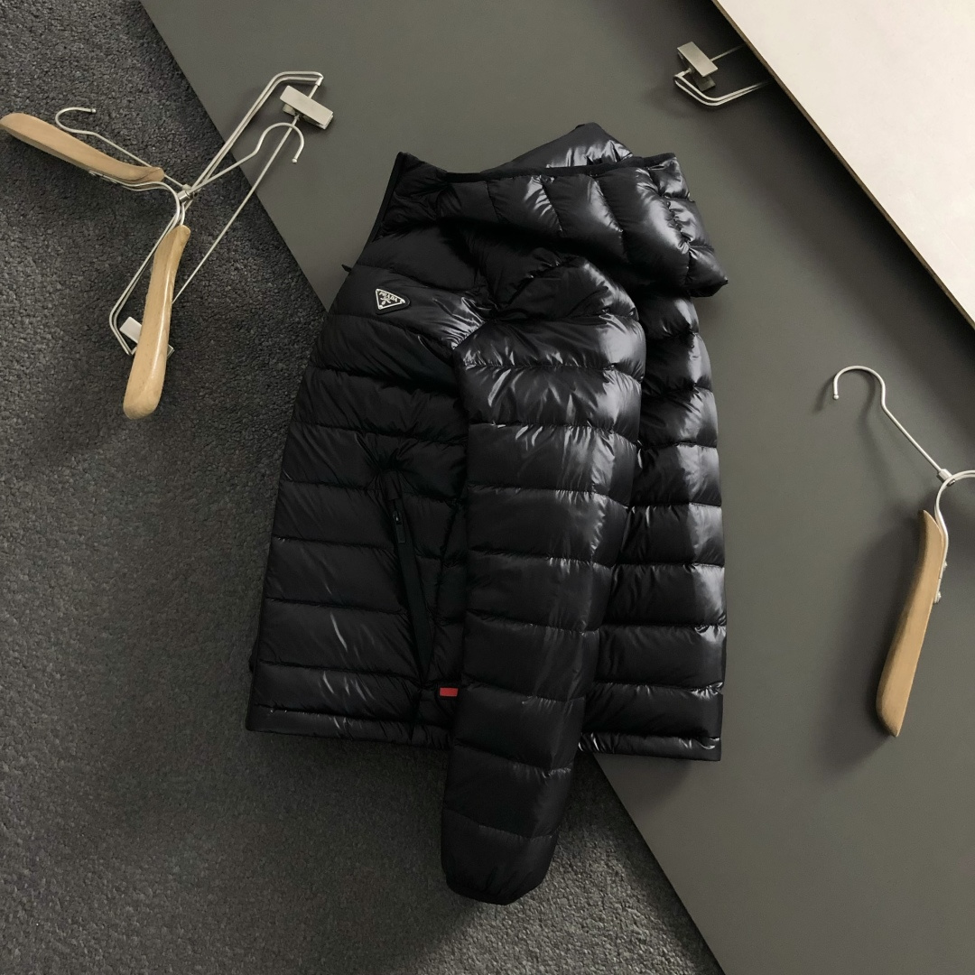 Prad*礼包版型48-562025秋冬90白鸭绒羽绒外套，以排骨冲绒发配金属三角标点缀为主调，融入内里