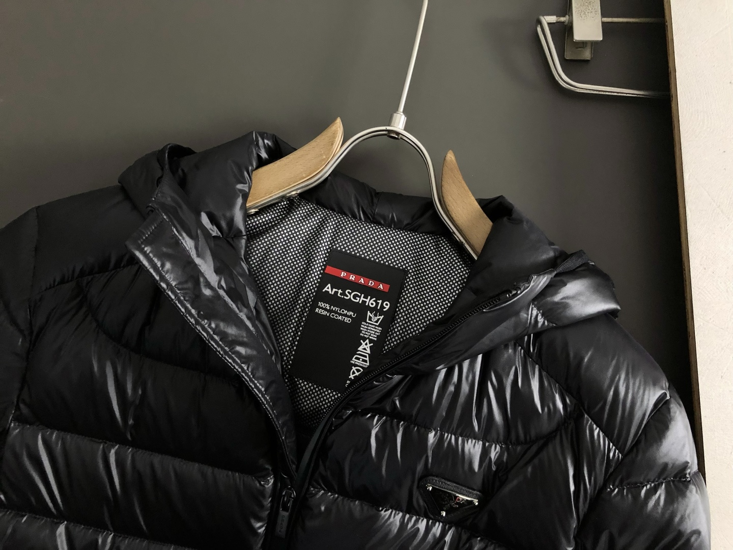 Prad*礼包版型48-562025秋冬90白鸭绒羽绒外套，以排骨冲绒发配金属三角标点缀为主调，融入内里