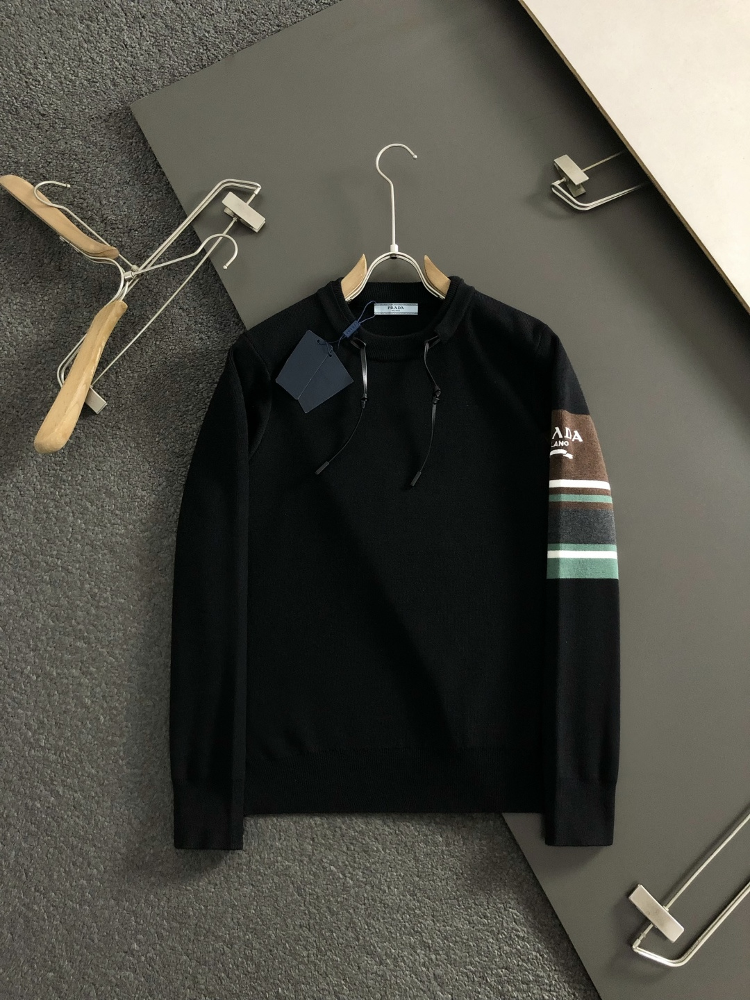 Prad*合身版型M-XXXl2025秋冬潮牌羊毛衫，以双领口皮绳搭配点缀为主调，巧妙袖子多色撞色提花字