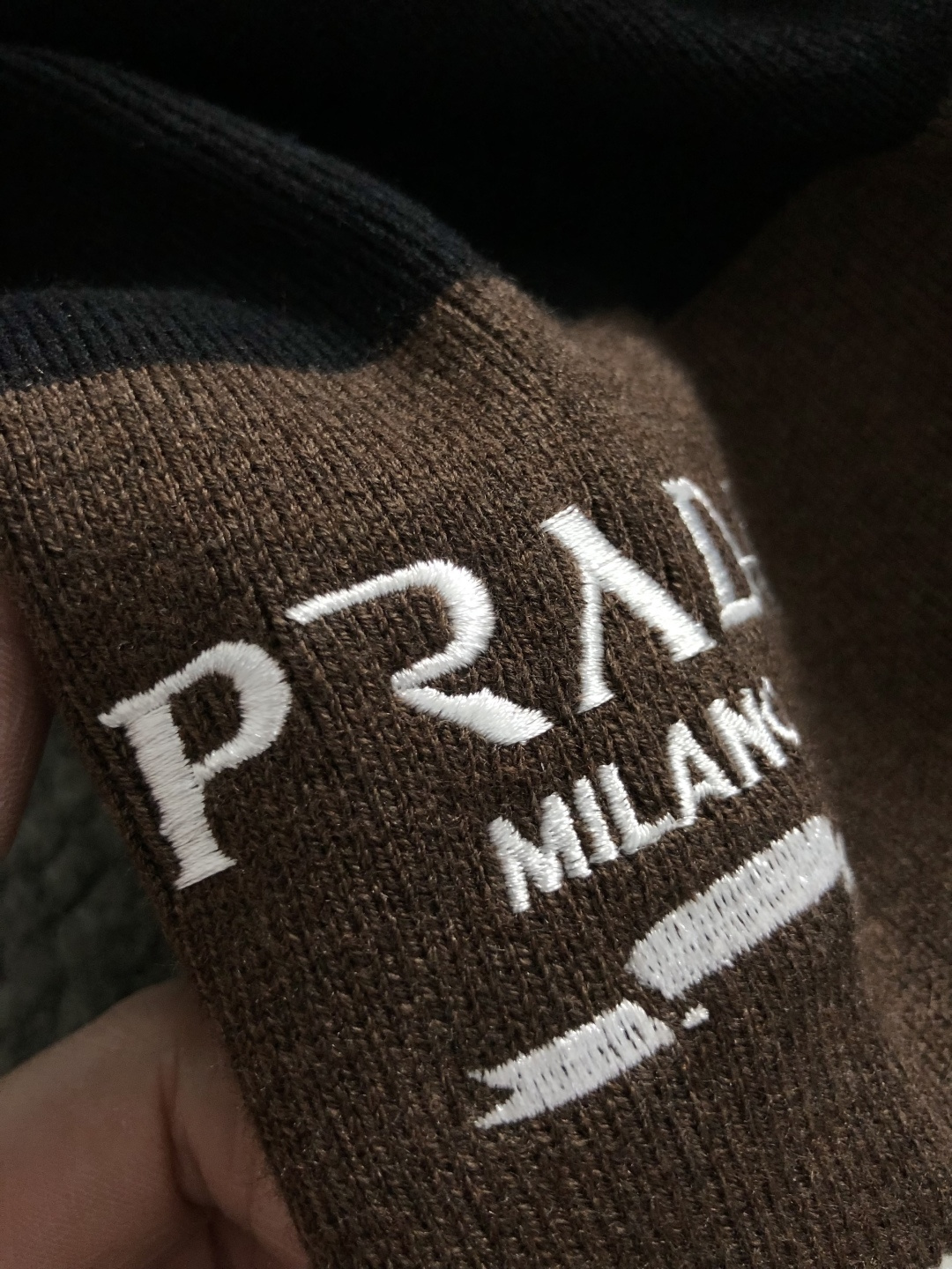 Prad*合身版型M-XXXl2025秋冬潮牌羊毛衫，以双领口皮绳搭配点缀为主调，巧妙袖子多色撞色提花字