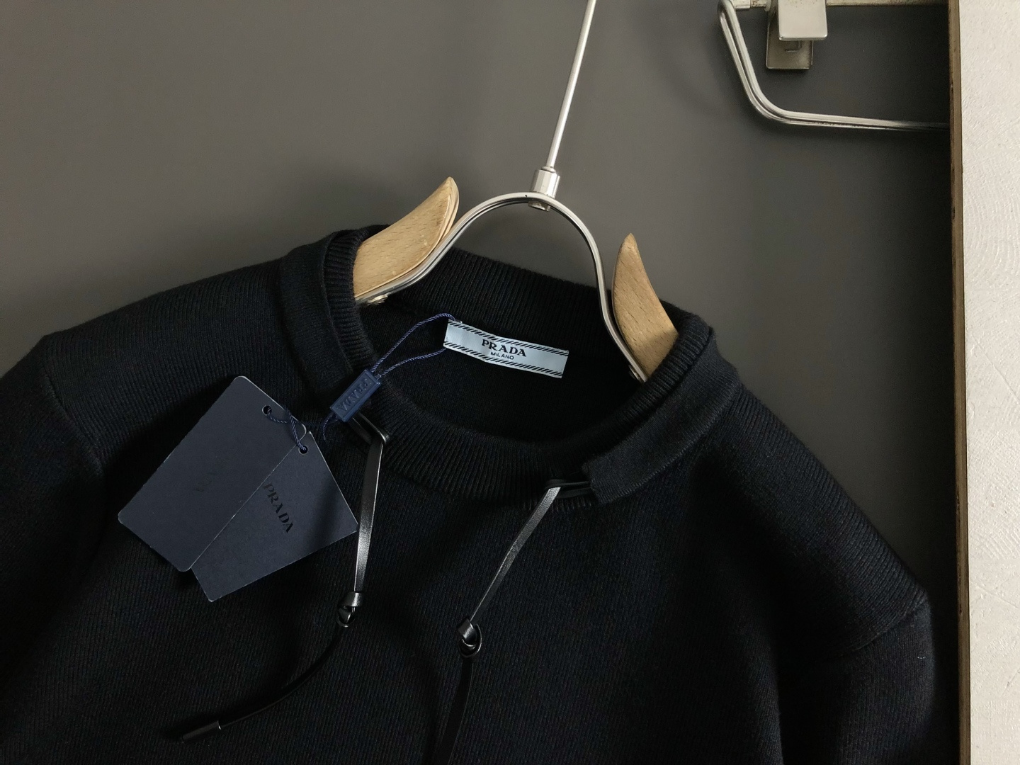 Prad*合身版型M-XXXl2025秋冬潮牌羊毛衫，以双领口皮绳搭配点缀为主调，巧妙袖子多色撞色提花字