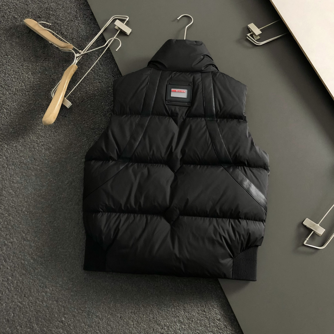 Prad*合身版型48-562025秋冬90白鸭绒羽绒马甲，以真皮贴皮元素点缀为主调，融入贴皮三角标元素