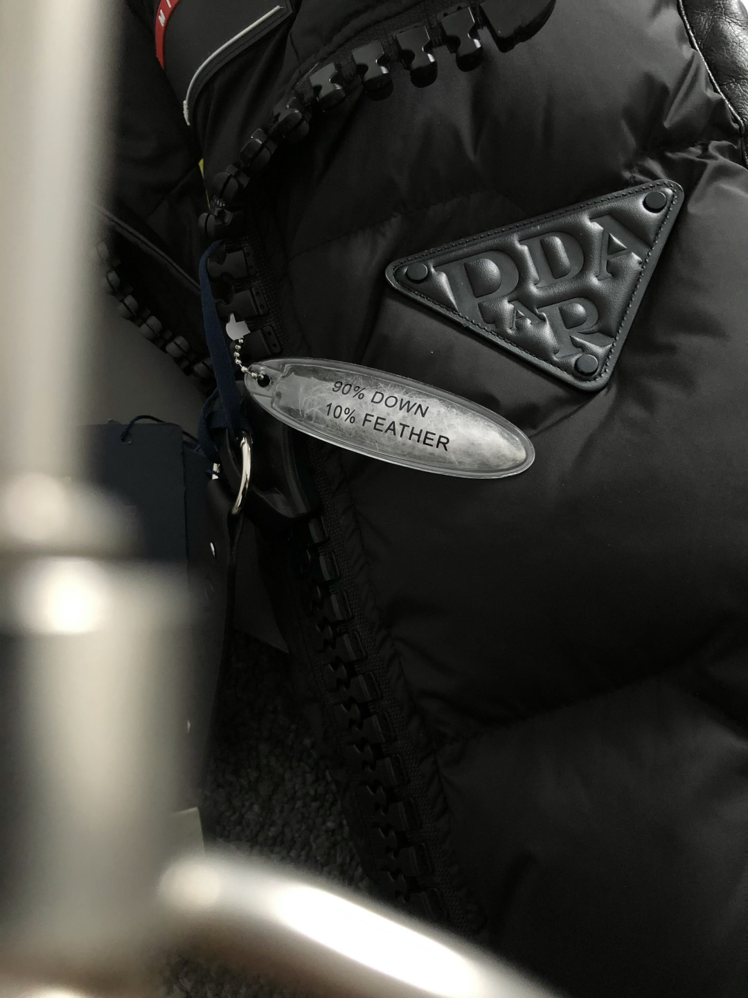 Prad*合身版型48-562025秋冬90白鸭绒羽绒马甲，以真皮贴皮元素点缀为主调，融入贴皮三角标元素