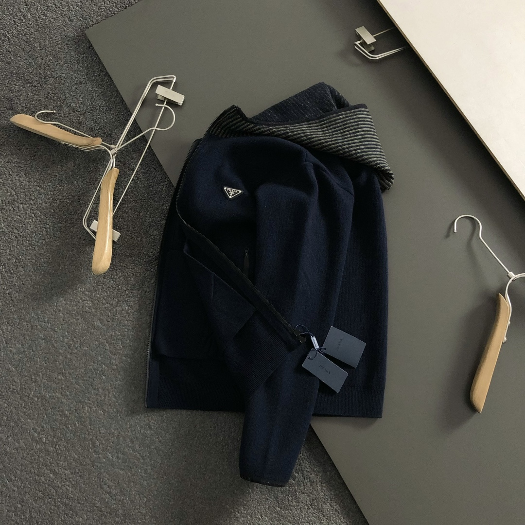 Prad*微宽版型M-XXXl2025秋冬潮牌针织开衫，以金属三角标点缀为主调，巧妙融入坑条撞色螺纹领拼