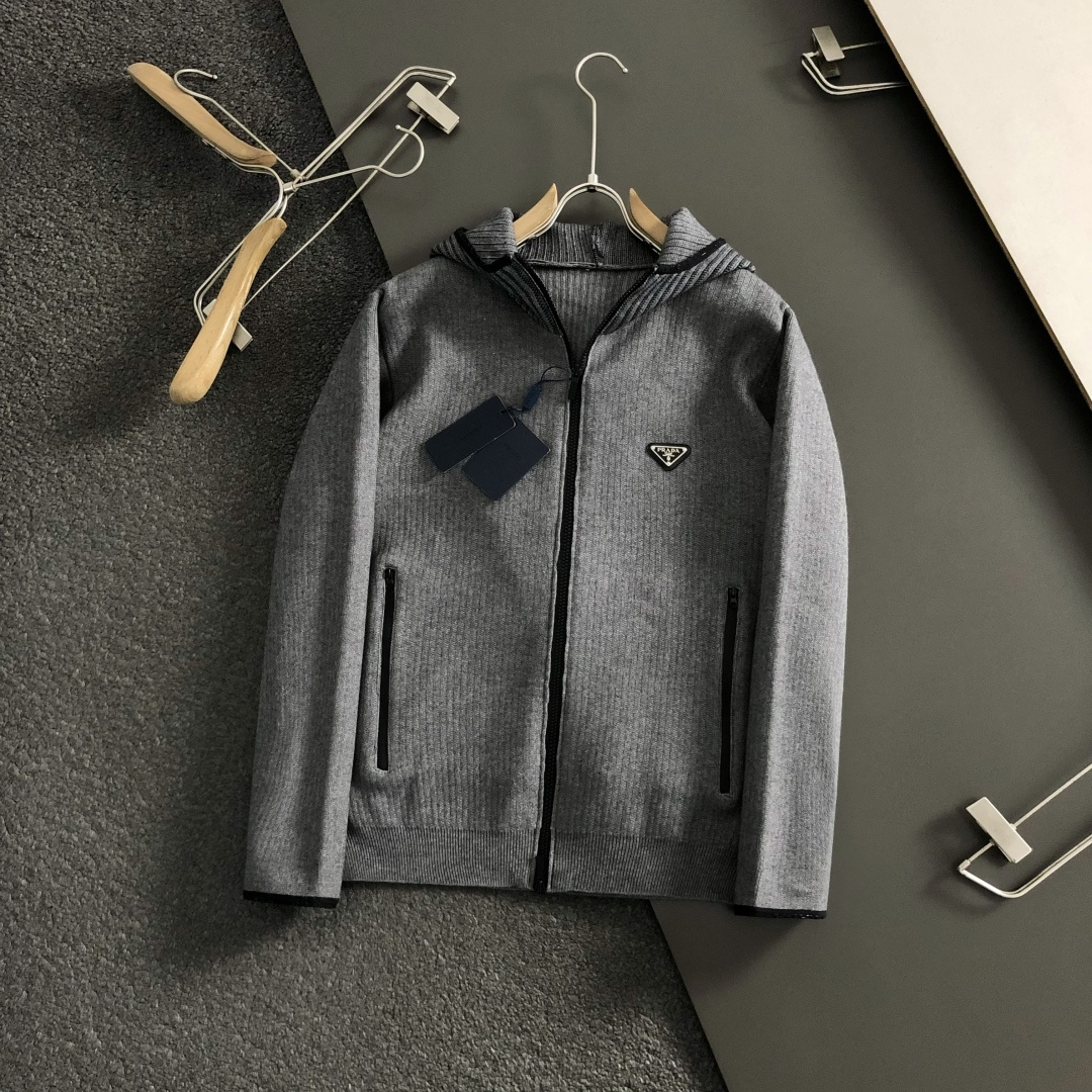 Prad*微宽版型M-XXXl2025秋冬潮牌针织开衫，以金属三角标点缀为主调，巧妙融入坑条撞色螺纹领拼