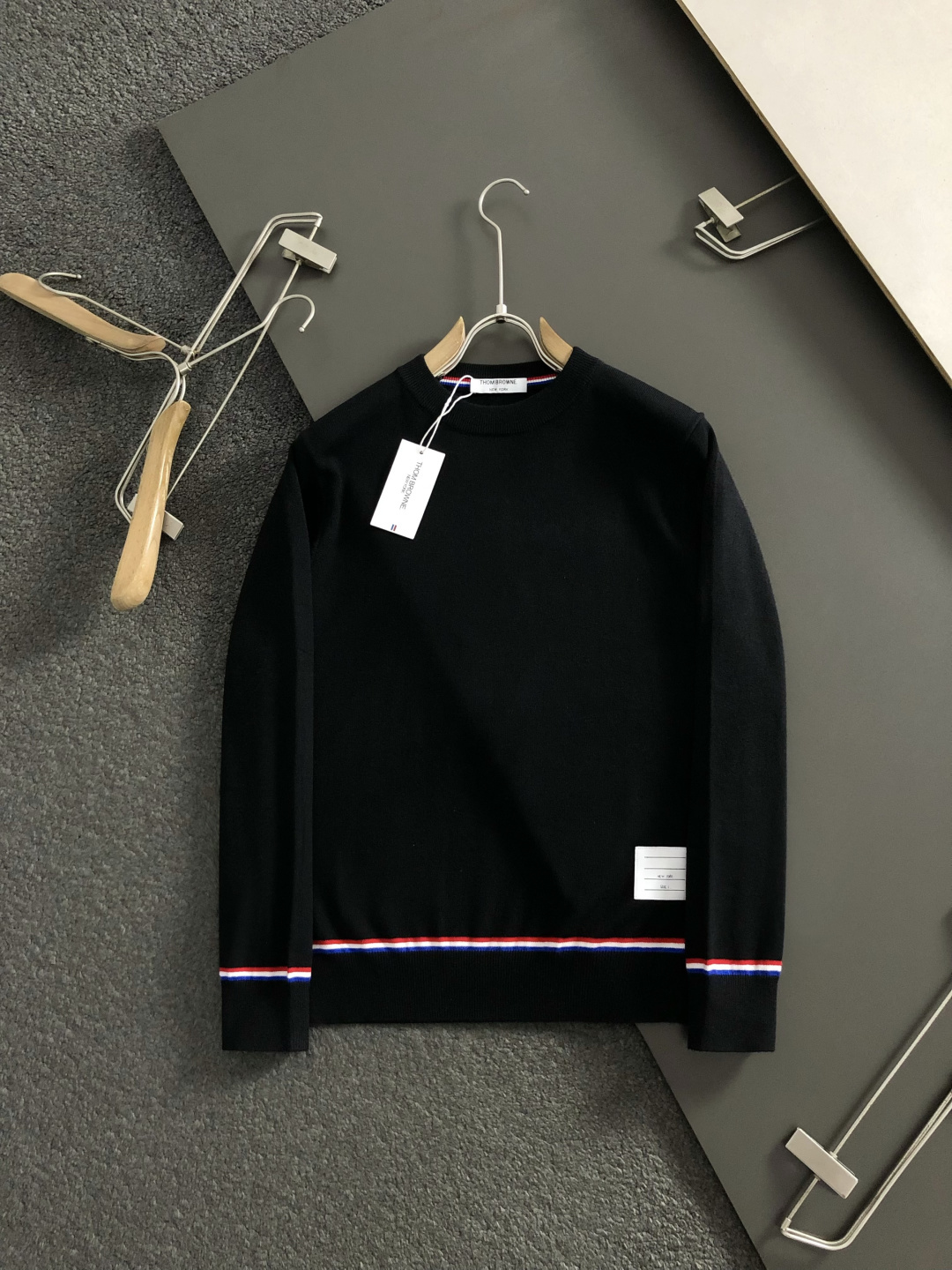 TB*合身版型M-XXXl2025秋冬潮牌圆领羊毛衫，以红黑撞色织带融合皮牌点缀为主调，巧妙融入后幅字母