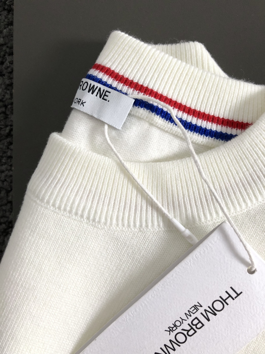 TB*合身版型M-XXXl2025秋冬潮牌圆领羊毛衫，以红黑撞色织带融合皮牌点缀为主调，巧妙融入后幅字母