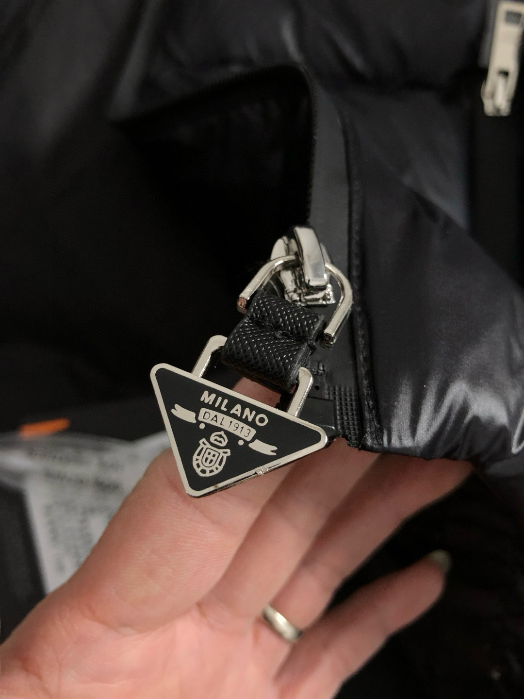 PRD*合身版型48-5625新款新面料黑色经典口袋融合金属三角标设计，金属附件打造90绒鸭绒立领外套，