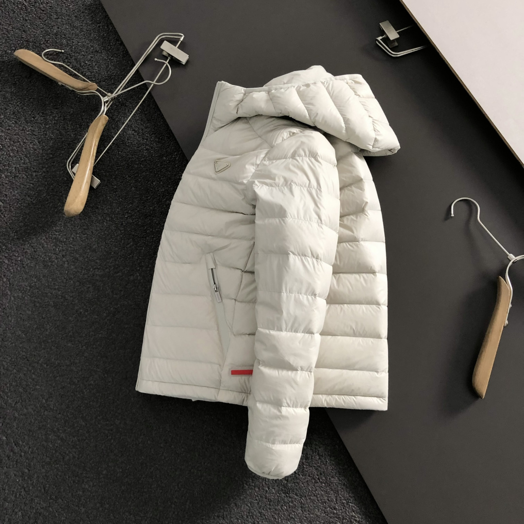 NO:660921,Prad* gift pack version 48-56  2025 Autumn and Winter 90 White Duck Down Jacket, with rib-blasted hair and metal triangle embellishments as the main theme, integrated with detachable handbag elements inside, and red letter leather strip splicing to break the monotony of traditional down, highlighting individuality and uninhibitedness. The three-dimensional tailoring fits the body shape, and the design is neat and stylish, easily elongating the leg lines, creating a casual and carefree look.  The casual style. The high-quality fabric is comfortable and warm, with both thermal insulation and comfort. It is suitable for daily outings or light outdoor scenes. The triangular jacquard embellishment on the back adds a fashionable texture. Whether it is a casual look with T-shirts and jeans, or a layered mix and match style, it can be easily controlled. It is an indispensable fashion item in the autumn and winter transition seasons.  Available colors: black, white, prada, jeans, jackets & coats, tees, t-shirt, down jacket,  19860909Prad*礼包版型48-56 2025秋冬90白鸭绒羽绒外套,以排骨冲绒发配金属三角标点缀为主调,融入内里可拆卸手提包元素,红色字母皮条拼接打破传统羽绒的单调感,彰显个性与不羁.立体剪裁贴合身形,设计利落有型,轻松拉长腿部线条,打造随性洒脱的休闲风格.优质面料舒适保暖,兼具保温性与舒适感,适合日常出街或轻户外场景.细节后背三角提花点缀,增添时尚质感,无论是搭配T恤牛仔裤的休闲look,还是叠的混搭风,都能轻松驾驭,是秋冬过渡季不可或缺的时尚单品. 现货颜色 黑色 白色,,prada,jeans,jackets & coats,tees，t-shirt,down jacket, ,Men's clothing